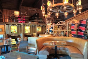 A rustic interior with leather seating, a wooden ceiling, and a chandelier.