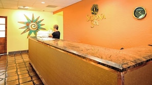 Una recepción con un reloj y el logotipo de 'Sedona Spa' en la pared.