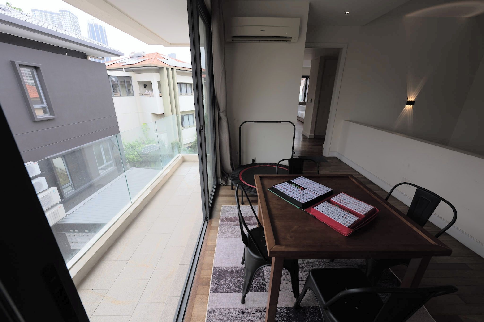 A balcony with a dining table, chairs, and a view of buildings.
