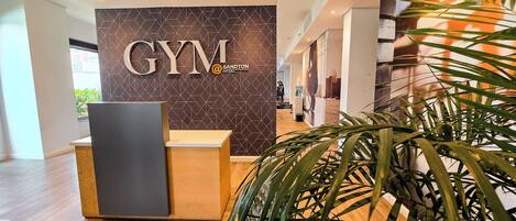 Una recepción con el logotipo de 'GYM Sandton Hotel' al fondo.