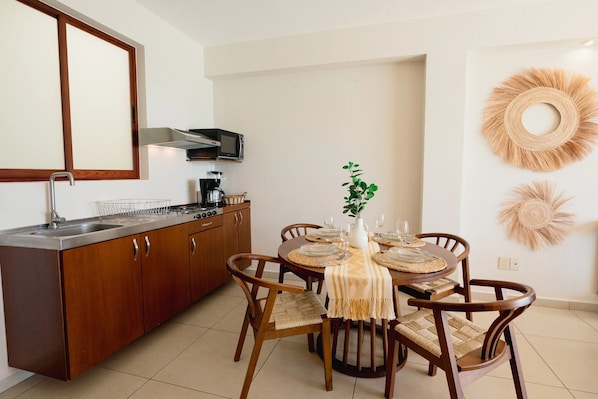 Una cocina moderna con comedor, que incluye microondas, estufa y pileta.