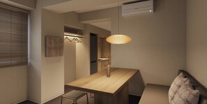 Una habitación de hotel moderna con una mesa de comedor de madera, un banco, una lámpara colgante y un aire acondicionado instalado en la pared.