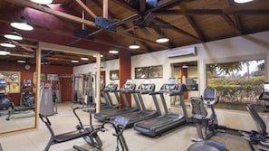Ein Fitnessstudio mit Laufbändern, Crosstrainern und Gewichten.