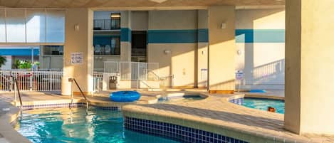 A pool area with multiple hot tubs and a diving board.
