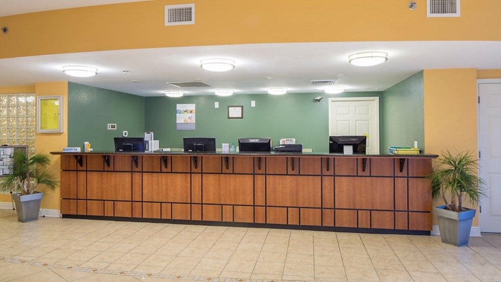A reception desk with a wooden panel design, a computer, and a telephone.