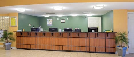 A reception desk with a wooden panel design, a computer, and a telephone.