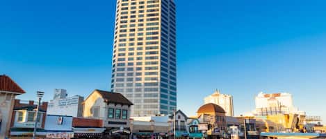 A tall building labeled "Atlantic Palace" with a modern design, surrounded by various shops and a waterfront promenade.