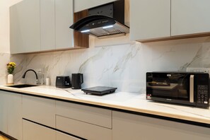 A modern kitchen with a built-in microwave, a toaster, and a coffee maker on the countertop.