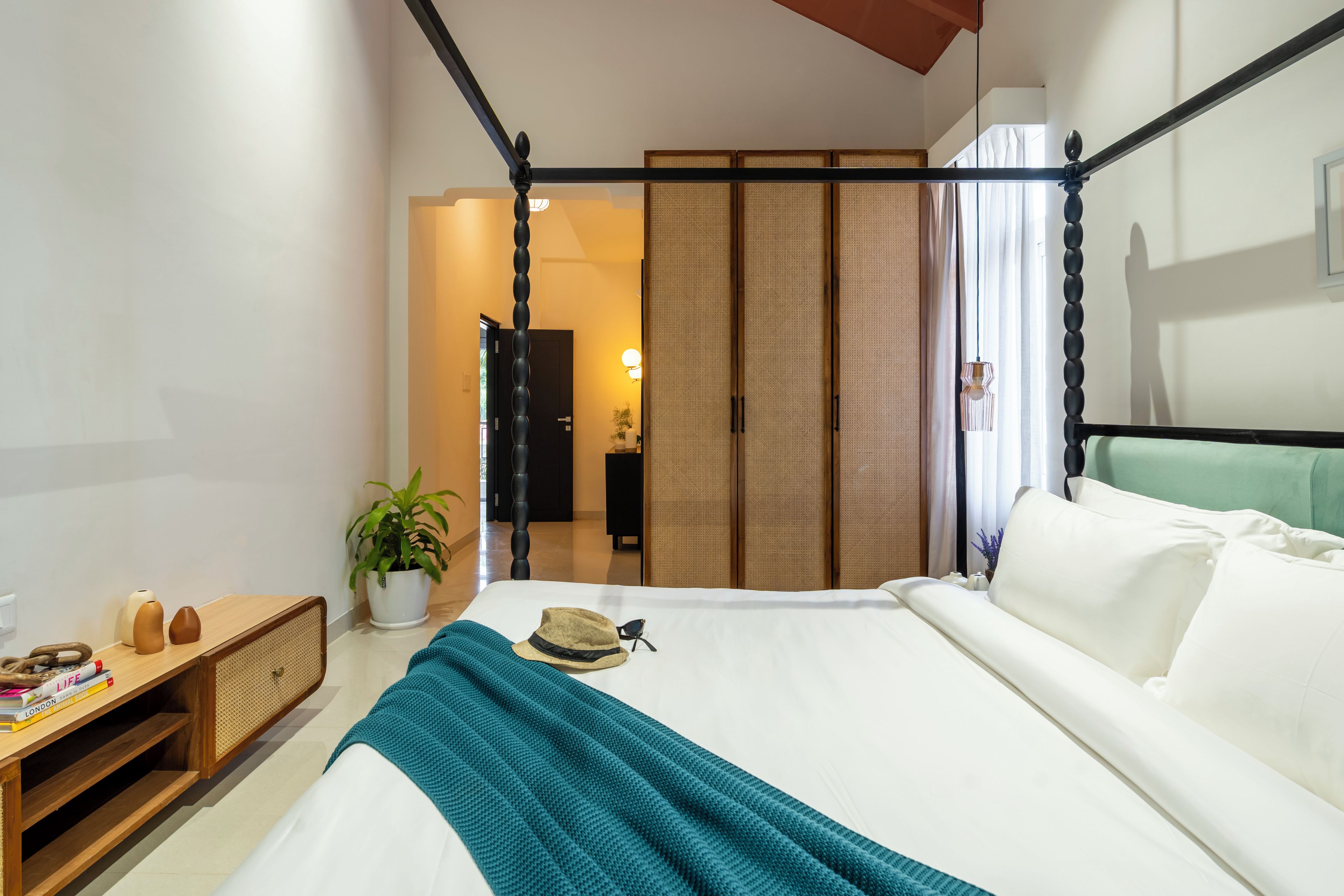 Une chambre d’hôtel avec un lit, une table de chevet et vue sur le couloir.
