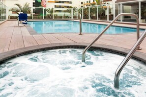 A hot tub with a metal ladder, a pool, and a blue chair. - Anaheim | Couples Disney Park Escape | Pool + Parks (Anaheim)