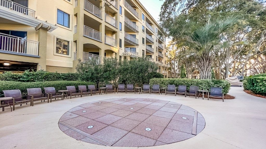 A courtyard with a circular seating area, surrounded by a multi-story building with balconies.