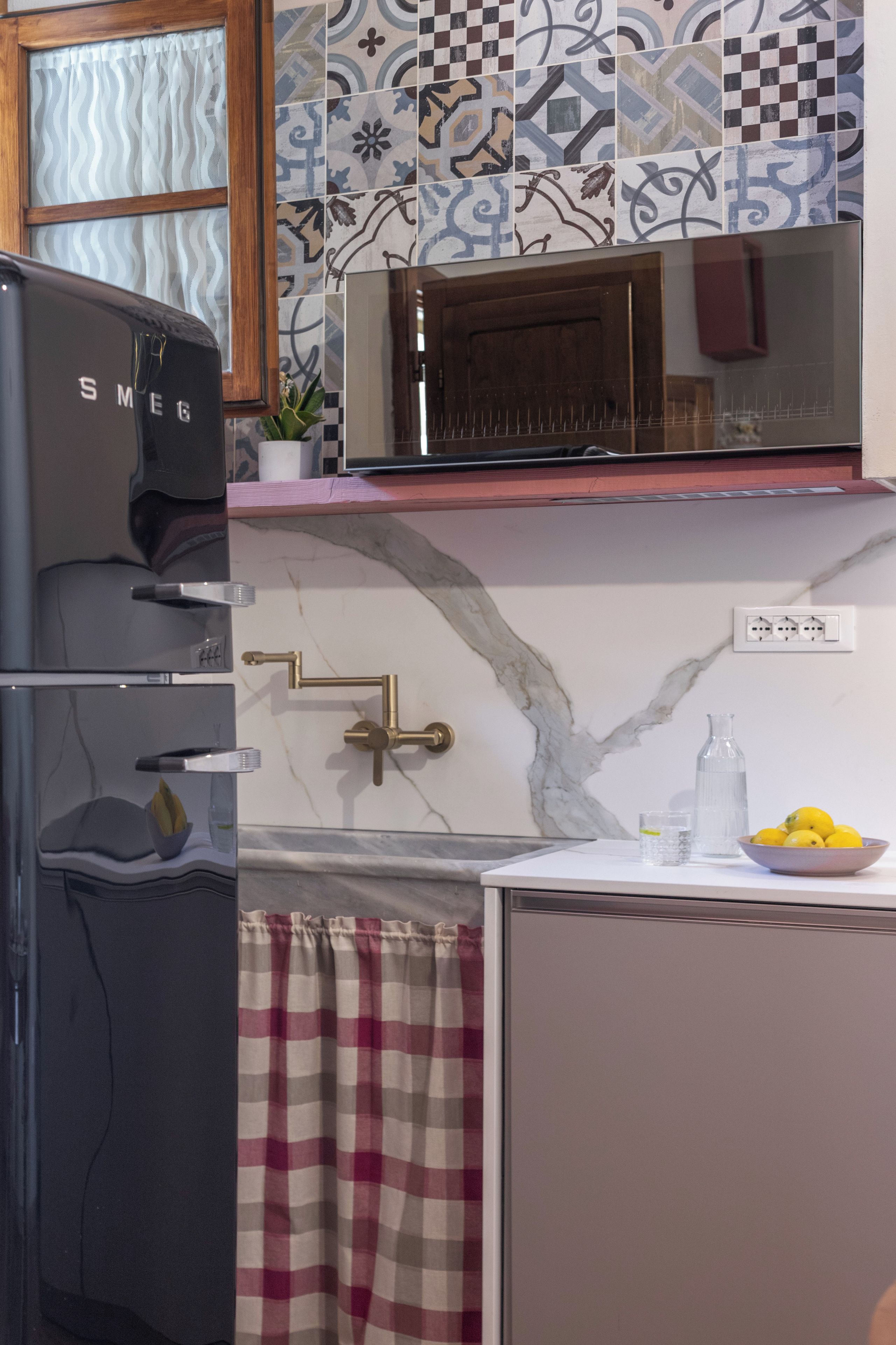 Cozinha equipada com geladeira, micro-ondas, pia e uma tigela de limões.