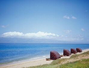 Ein Strand mit Liegestühlen und freiem Blick aufs Meer.