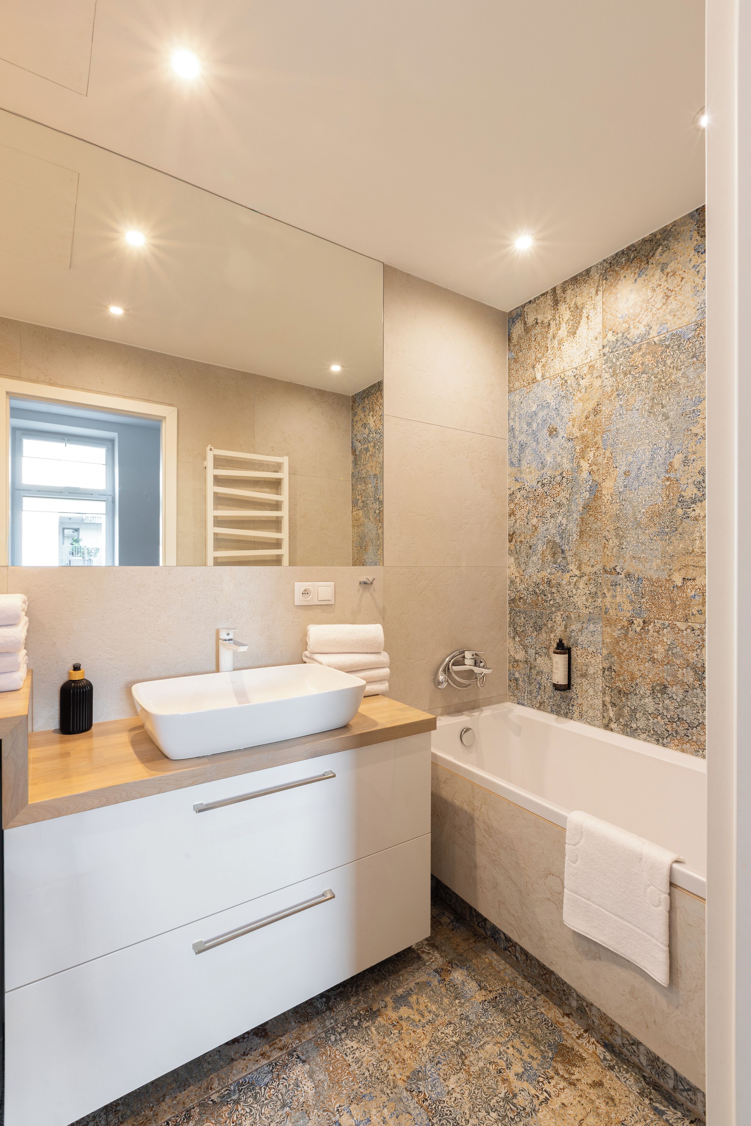 Une salle de bain moderne avec une baignoire sur pieds, un meuble-lavabo à deux vasques et un grand miroir.