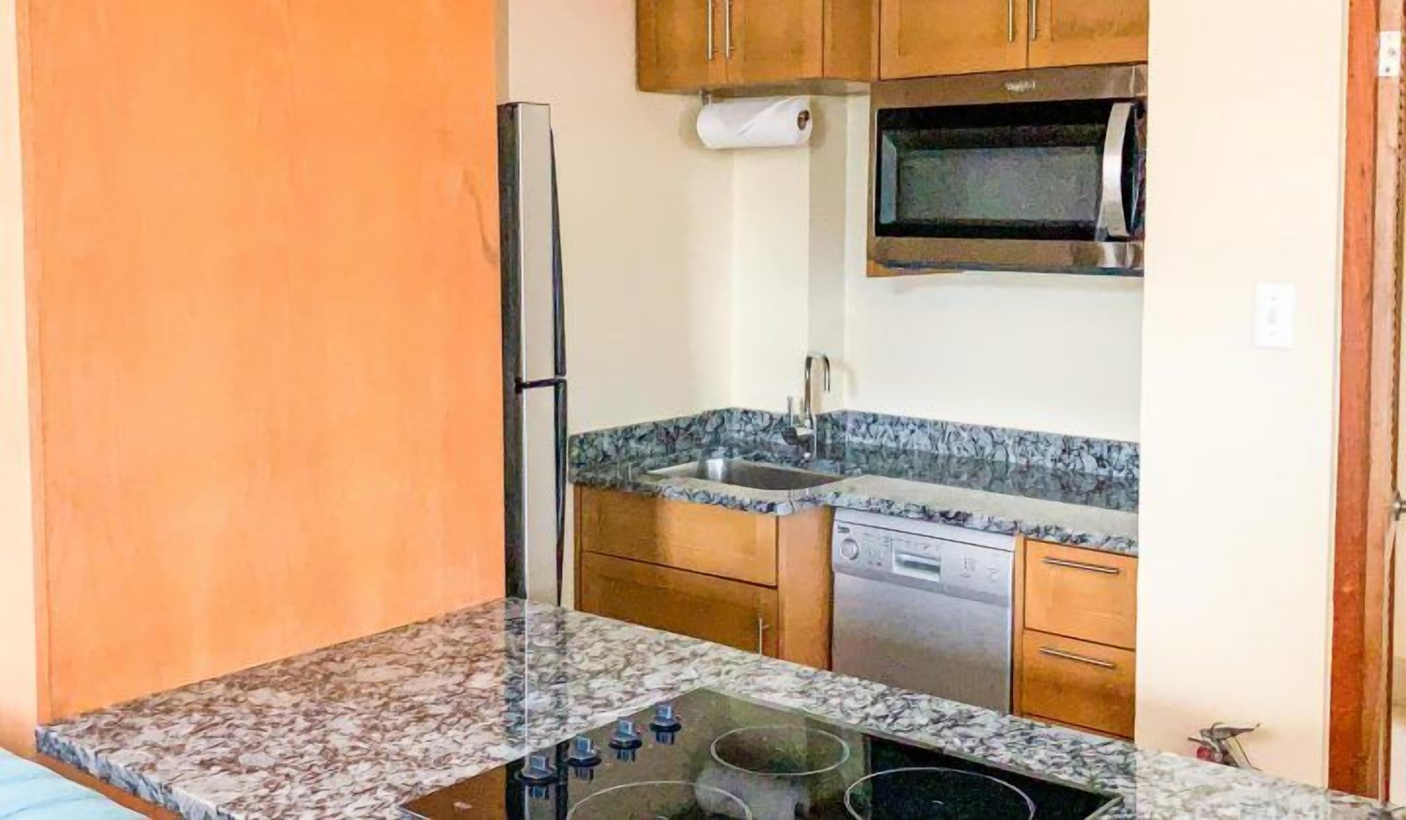 A compact kitchen with a microwave, stove, and dishwasher.