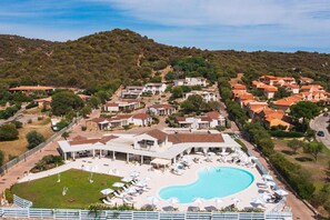 A resort with a swimming pool, multiple villas, and a hilly backdrop. - Piccolo Hotel (Porto Ottiolu)