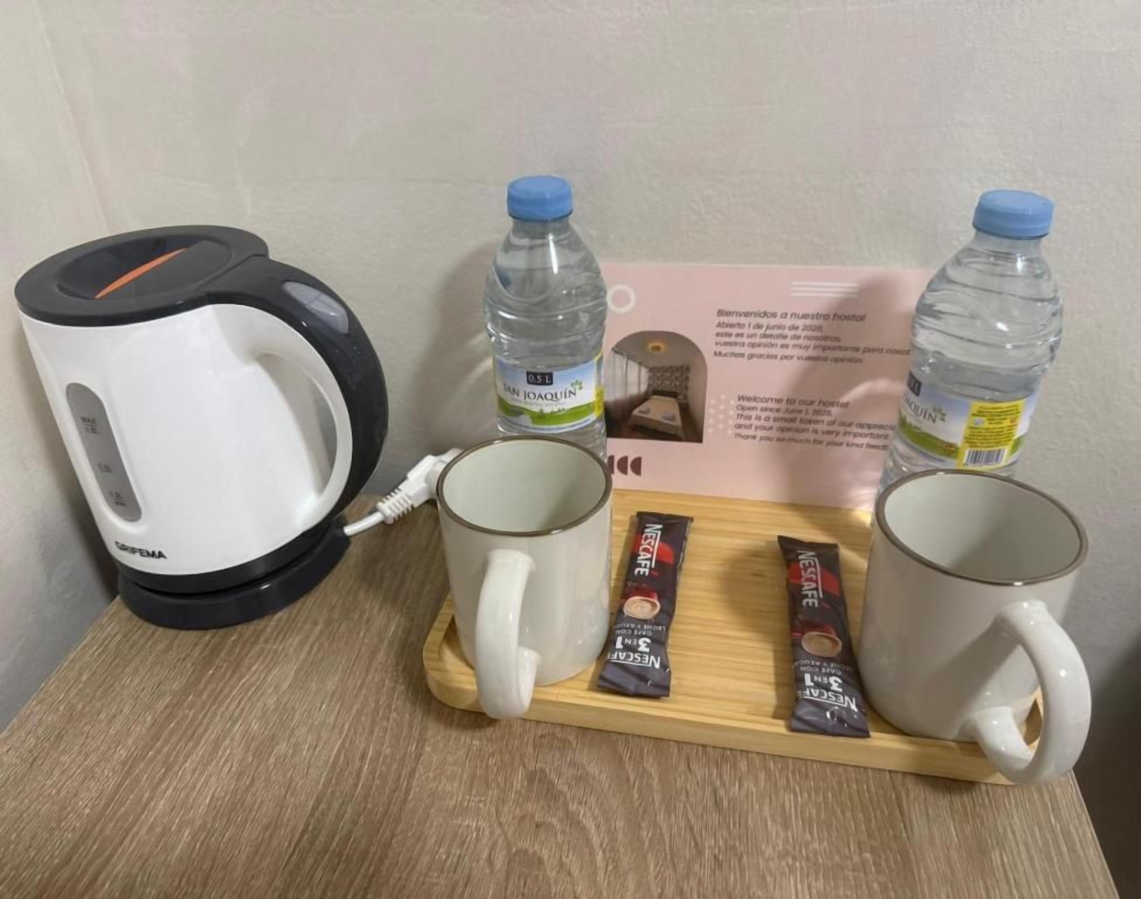 Une machine à café, deux bouteilles d’eau et deux paquets de café Nespresso sur un plateau.