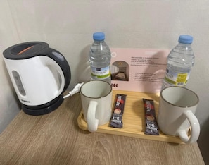 A coffee maker, two water bottles, and two packets of Nespresso coffee on a tray. - Multi Hostal BM 71 (Madrid)