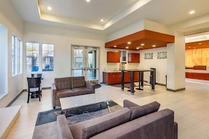 A spacious living area with a sofa set, a dining table, and a kitchen area with wooden cabinets. - Las Vegas | Couples Vegas Escape | Pool + Hot Tub (Las Vegas)