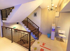 A hotel room with a staircase, a chandelier, a desk, and a trash bin. - De Uptown Hotel Subang Jaya by Easy Nap (Subang Jaya)