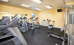 Ein Fitnessraum mit Laufbändern, Crosstrainern und Krafttrainingsgeräten.