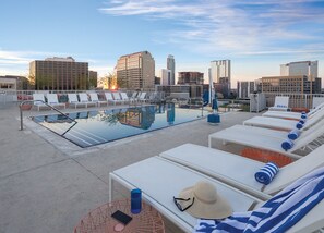 A rooftop pool with lounge chairs, a table, and a hat. - Austin | Urban Retreat | Pool + Downtown Access (Austin)