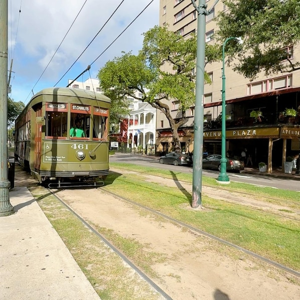 Un tramway vert portant le numéro 461 circule sur une voie ferrée, passant devant un bâtiment sur lequel on peut lire les inscriptions « ST. CHARLES » et « AVENUE PLAZA ».