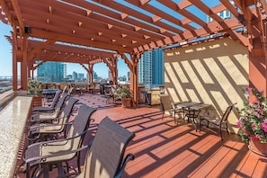 Une terrasse sur le toit avec des sièges extérieurs, une pergola et une vue sur la ville.