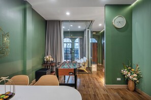 Una habitación moderna con mesa de futbolín, sofá y mesa de comedor.