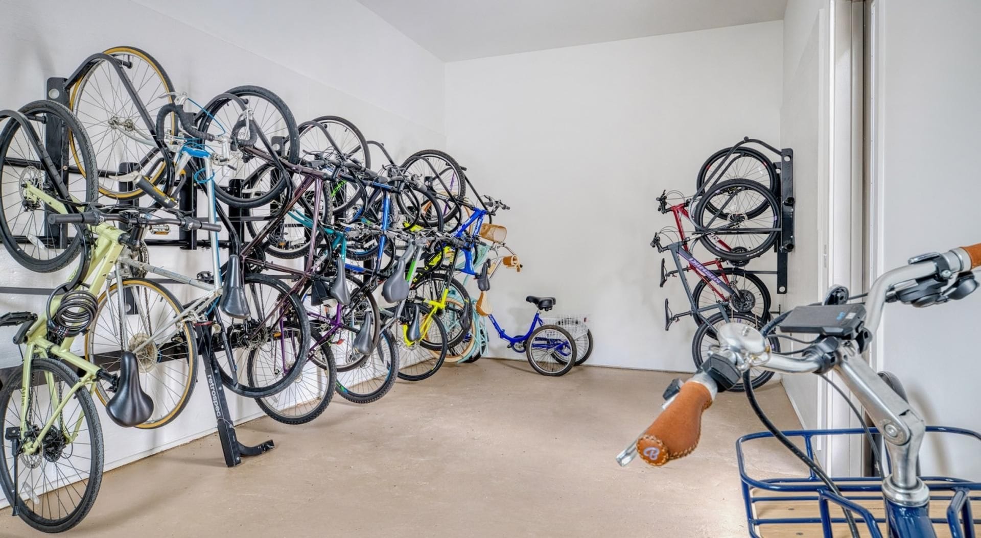 Quarto com bicicletas fixadas na parede e um braço robótico.