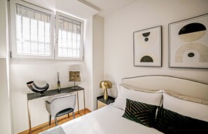 A bedroom with a bed, a desk, a chair, and two wall-mounted artworks. - Repvblic Lux (Milano)
