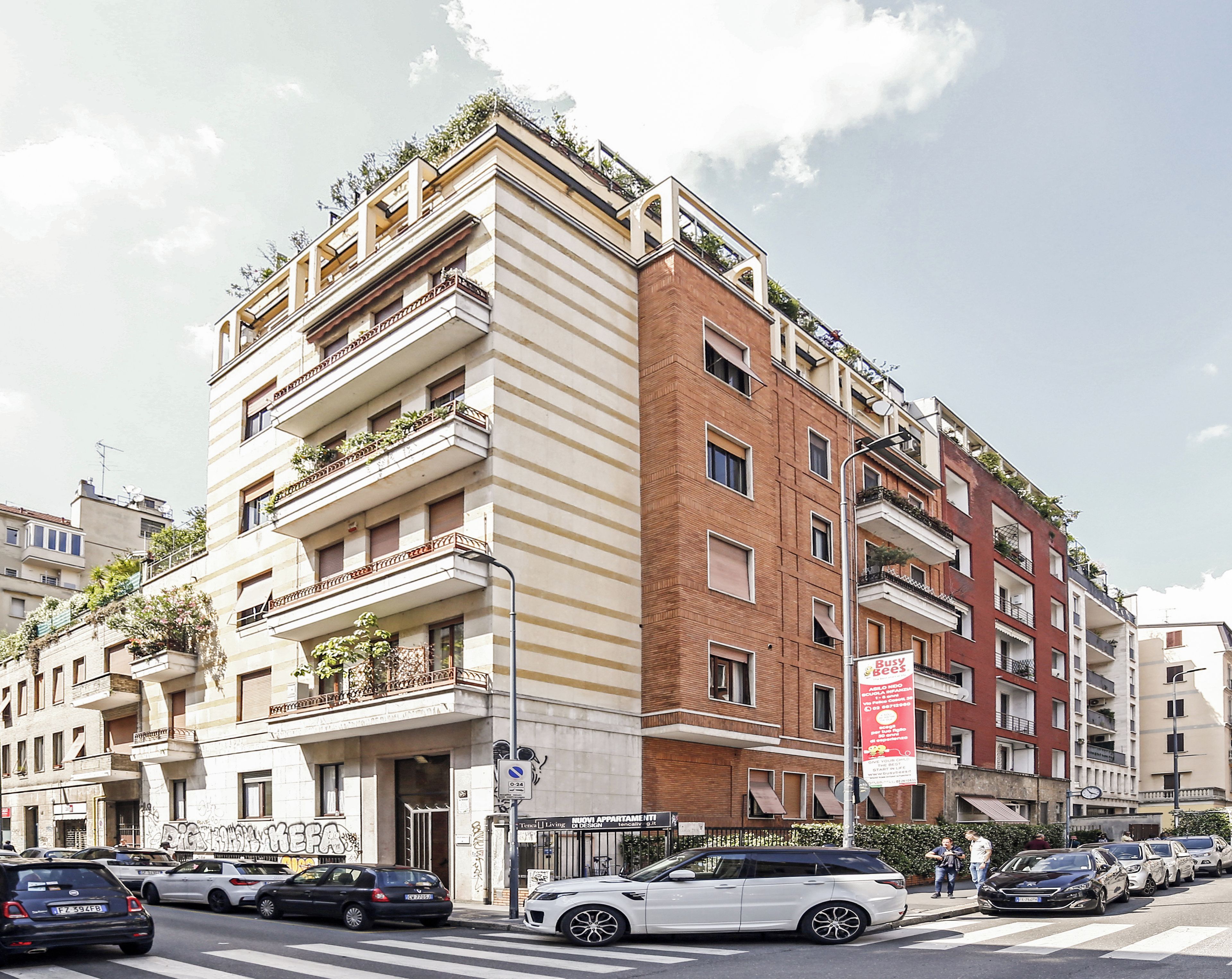 A multi-story building with balconies, a sign for 'Busy Bees,' and a street with parked cars.