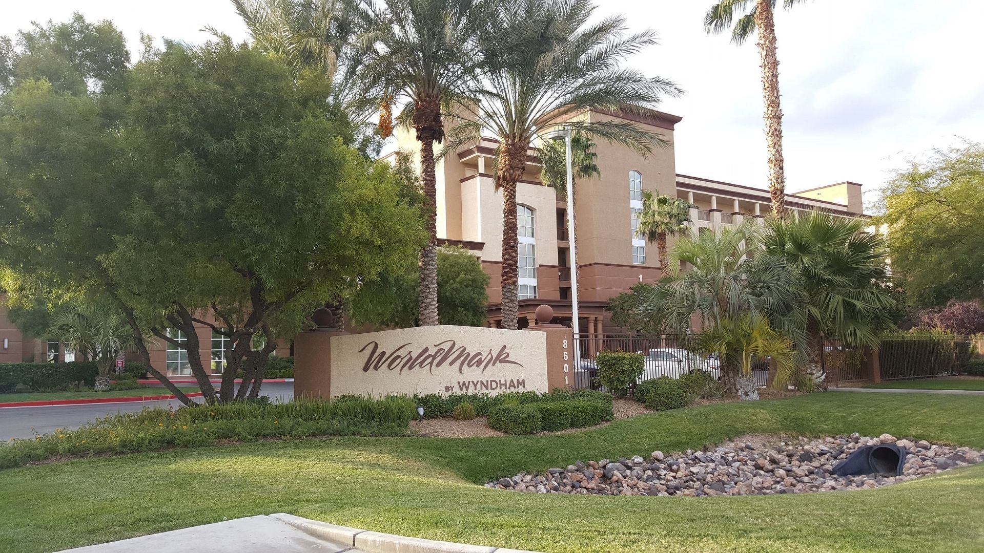 A hotel sign with the name 'Wyndham' and a building in the background.