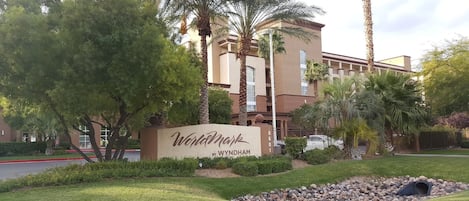 A hotel sign with the name 'Wyndham' and a building in the background.