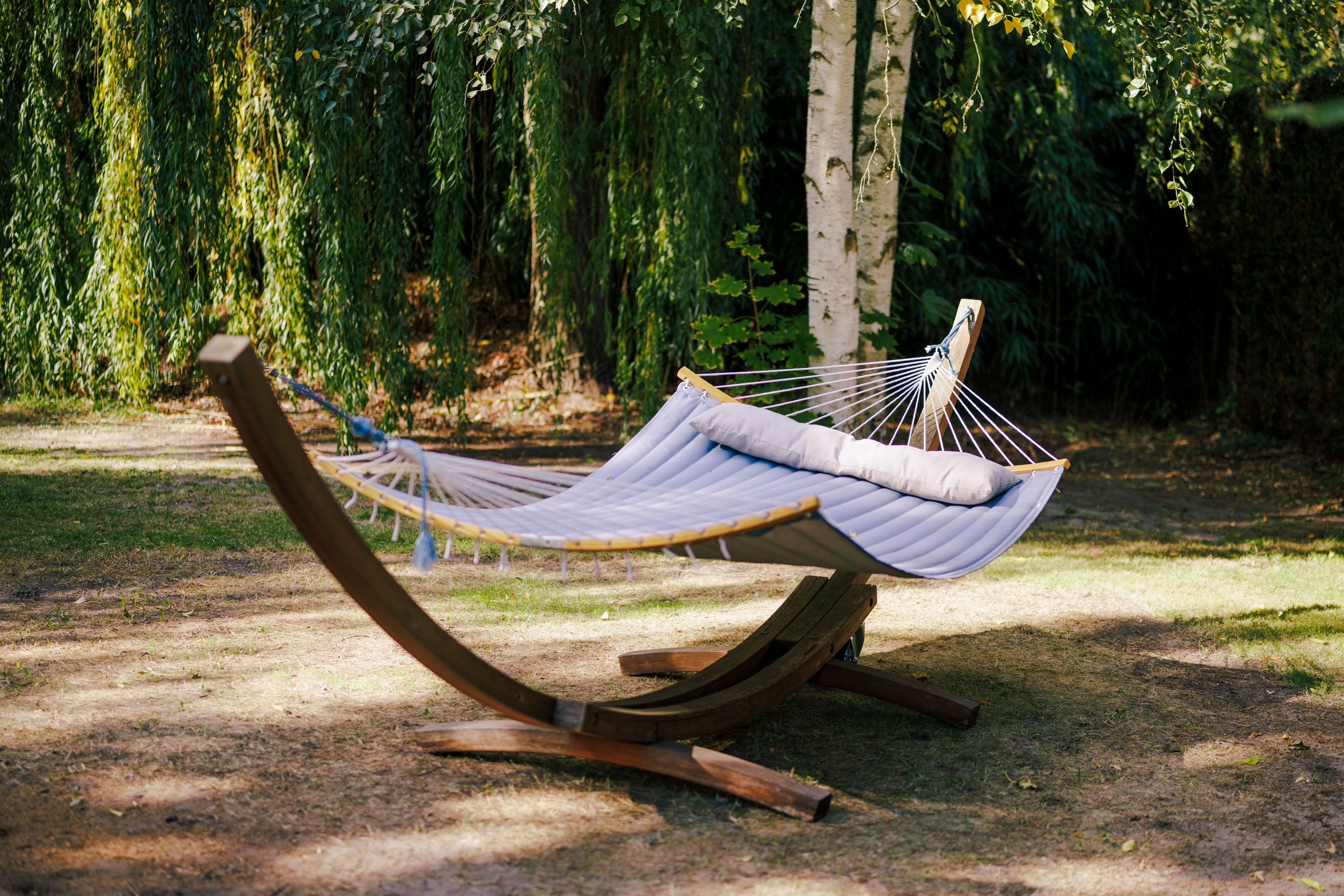 Un hamac dans un parc, avec des arbres en arrière-plan.