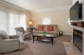 A living room with a sofa, armchairs, a coffee table, a TV, and a fireplace. - Clear Lake | Cozy Lake Retreat | Pool + Lake (Nice)
