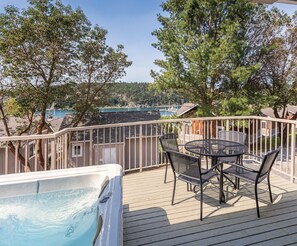 A deck with a hot tub, outdoor seating, and a view of a marina. - Deer Harbor | Relaxing Cottage Retreat | Pool + Marina (Deer Harbor)