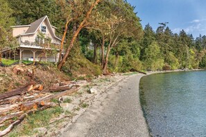 A house with a balcony overlooking a lake, surrounded by trees and a gravel path. - Deer Harbor | Relaxing Cottage Retreat | Pool + Marina (Deer Harbor)