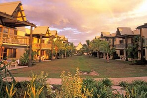 A resort with multiple buildings, a central lawn, and tropical vegetation. - Denarau | Group Island Paradise | Full Kitchen & Balcony | 2BR (Nadi)