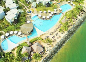 A resort with multiple swimming pools, sun loungers, and palm trees. - Denarau | Group Island Paradise | Full Kitchen & Balcony | 2BR (Nadi)