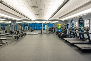A gym with various exercise equipment, including treadmills, weight machines, and a mirrored wall. - Indio | Desert Weekend Escape | Pool & Lazy River | 2BR (Indio)