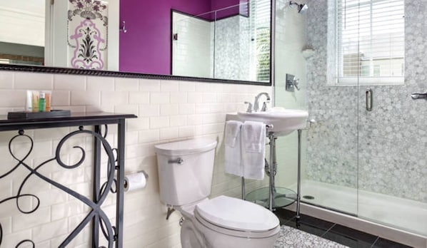 Un bany amb vàter blanc, un lavabo i una dutxa.
