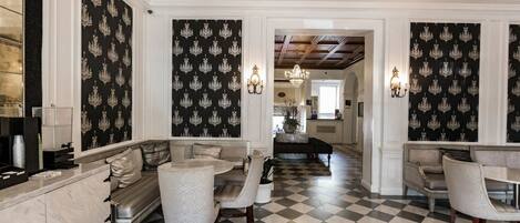A spacious living area with a checkered floor, a sofa set, and a chandelier.