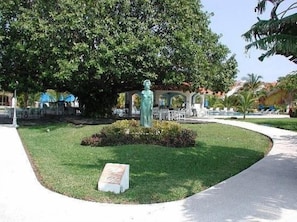 A statue in a landscaped area with a paved walkway and a pool in the background. - Isla Mujeres | Romantic Beach Retreat | Pool + Beach (Isla Mujeres)