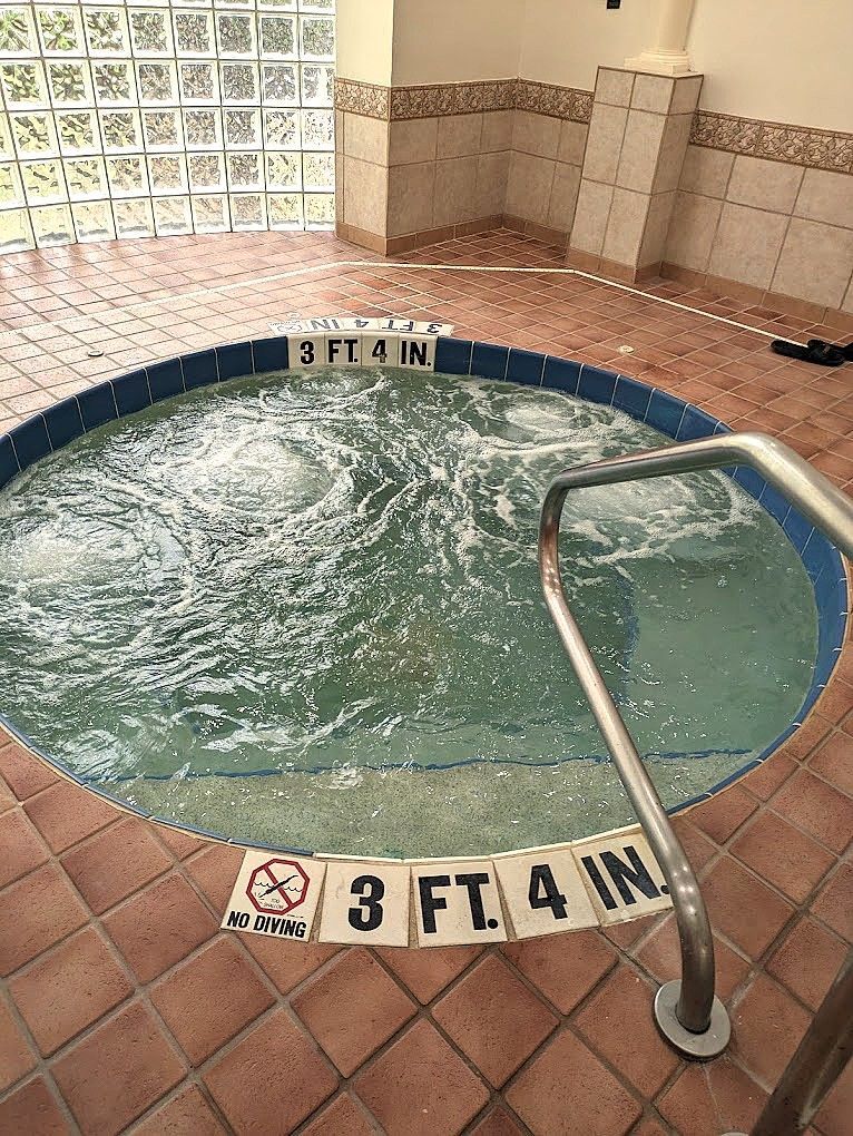 Un bain à remous dont la profondeur est indiquée par le marquage « 3 PIEDS 4 POUCES » et sur lequel est apposé un panneau indiquant « INTERDIT DE PLONGER ».