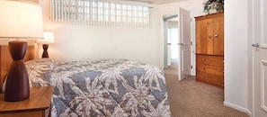 A bedroom with a bed, a nightstand, a wooden wardrobe, and a window with blinds. - Palm Springs | Romantic Desert Retreat | Pool + Hot Tub (Palm Springs)