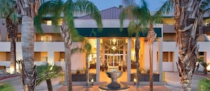 A hotel with a central courtyard, palm trees, and a fountain. - Palm Springs | Group Desert Retreat | Pool + Hot Tub | 2BR (Palm Springs)