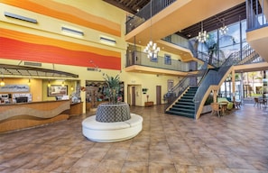 A spacious lobby with a central seating area, a staircase, and a reception desk. - Palm Springs | Group Desert Retreat | Pool + Hot Tub | 2BR (Palm Springs)