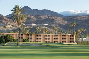 A golf course with a building featuring multiple balconies and a mountainous backdrop. - Palm Springs | Couples Desert Retreat | Pool + Hot Tub (Palm Springs)