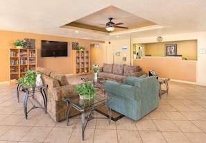A hotel lobby with a reception desk, sofas, a coffee table, and a bookshelf. - Palm Springs | Couples Desert Retreat | Pool + Hot Tub (Palm Springs)